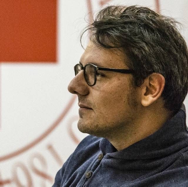 Luca di profilo davanti all'emblema della Croce Rossa Italiana
